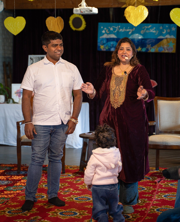 Dr. Monika guiding a father and child on stage